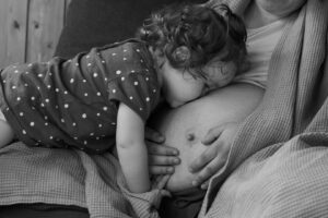 MAIdesign | Babybauch Shooting Kind küsst Bauch